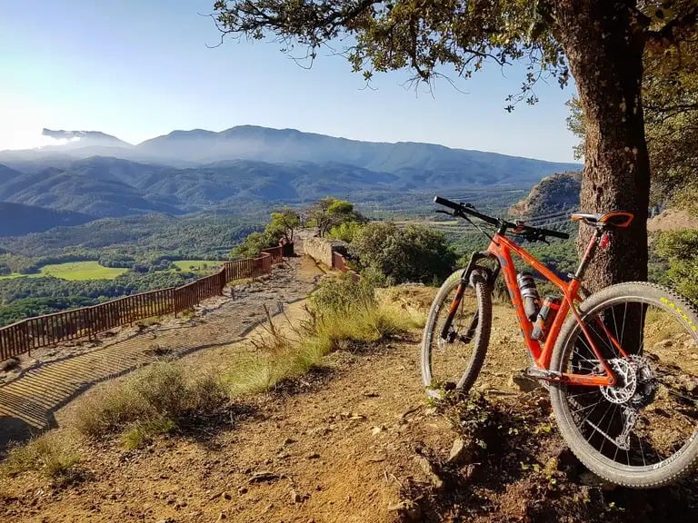Bicicleta de muntanya en un camí amb vistes a les muntanyes d'Osona